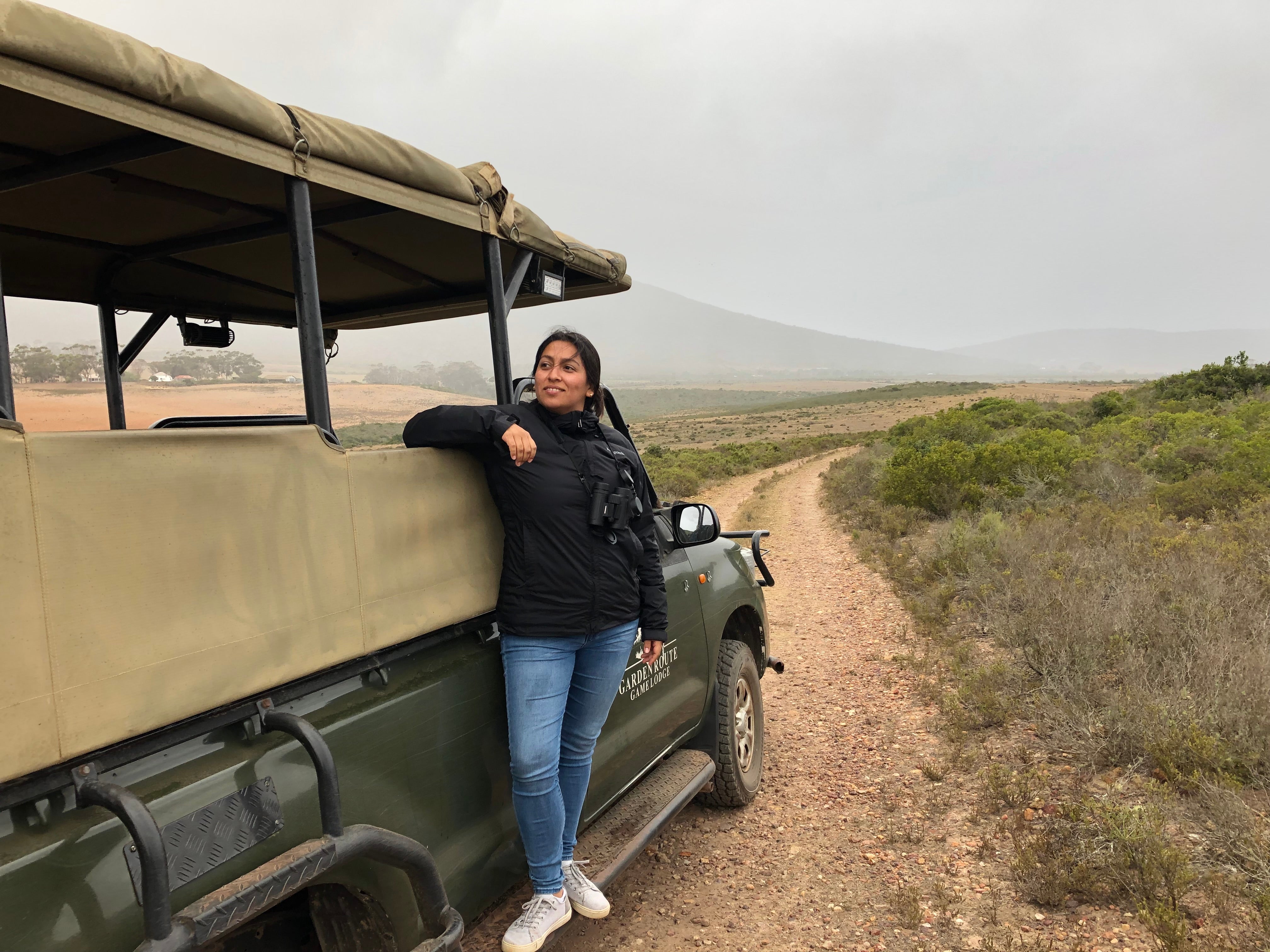 Woman leans against safari vehicle in South Africa
