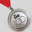 A silver medal that has the number 100 inscribed on it