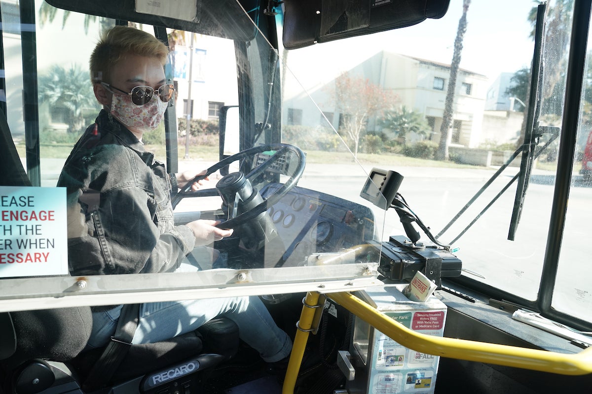 A unitrans driver looks over their shoulder from behind the wheel at UC Davis. 