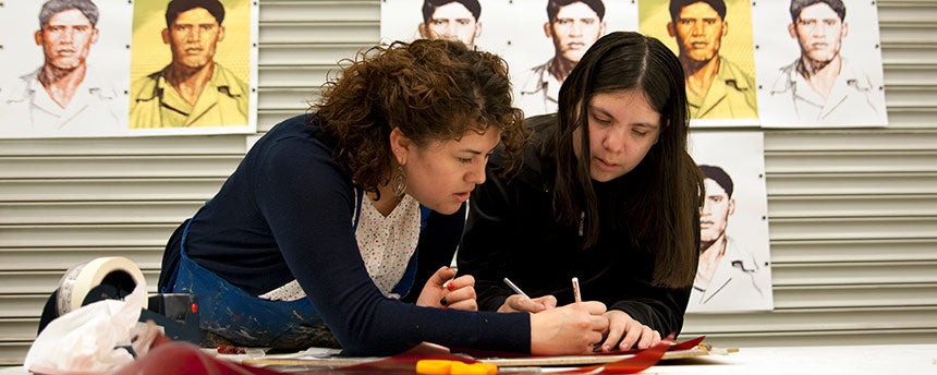 Two women in an art studio working on a screen printing