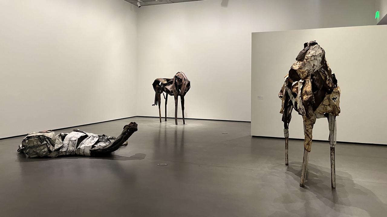 three horse scultpures in a gallery