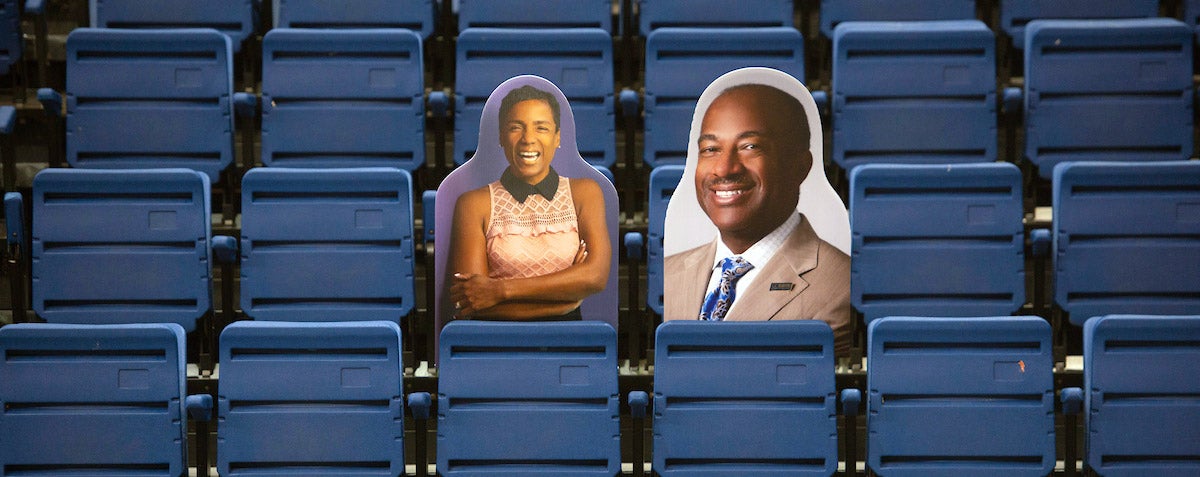 Cardboard cutouts of Gary and LeShelle May in basketball stands.