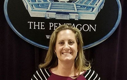 Jenna Gadberry poses in front of the Pentagon seal.