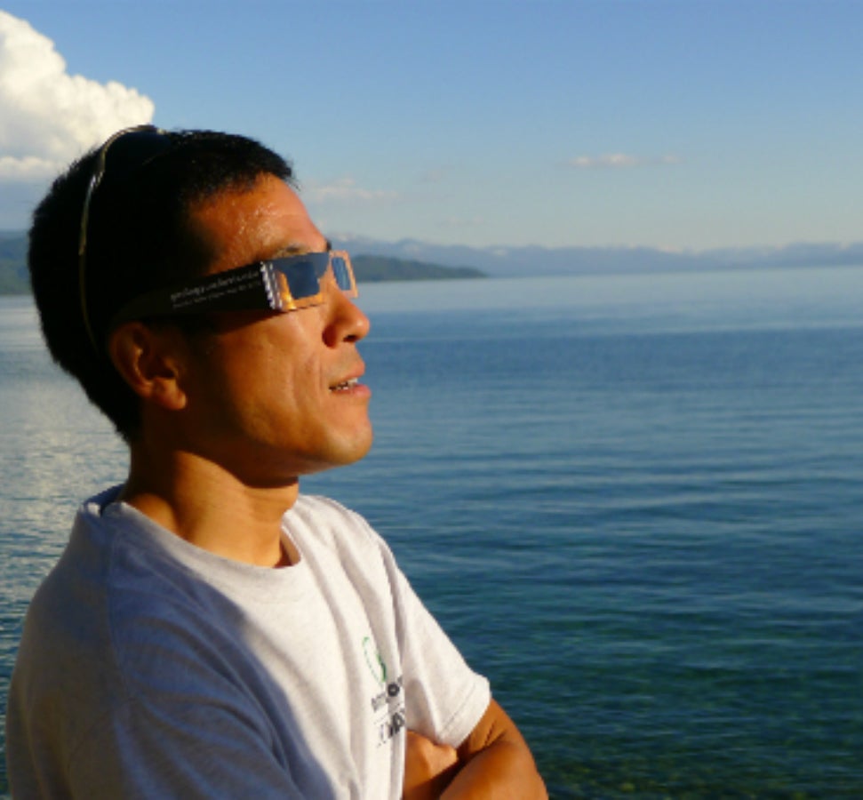 Kentaro Inoue, in sunglasses, gazing upon open water.