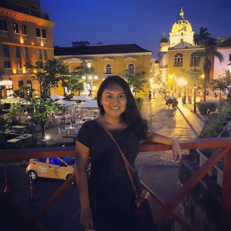 Cindy poses in front of a street with a lit dome in the background at night - linguistics major