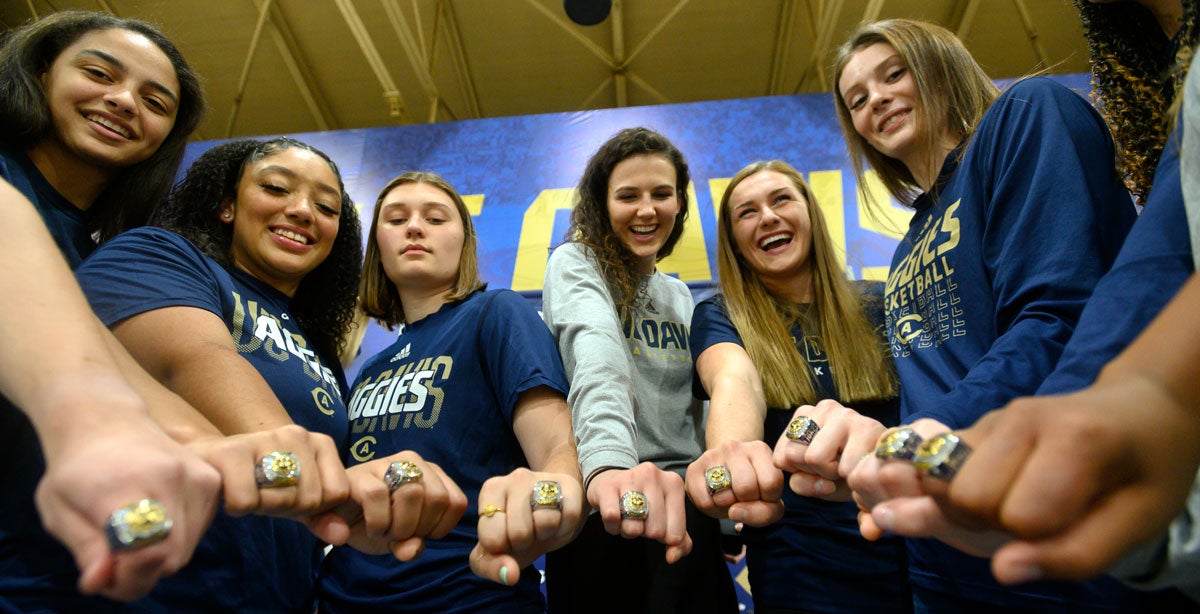 Basketball players show off their championship rings.