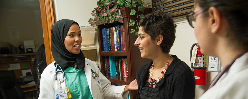 Medical students Ifrah Ali, left, and Talin Arslanian, right, chat with a chats with an undergraduate volunteer, Simirin Atwal,  during their shift at the Shifa Community Clinic