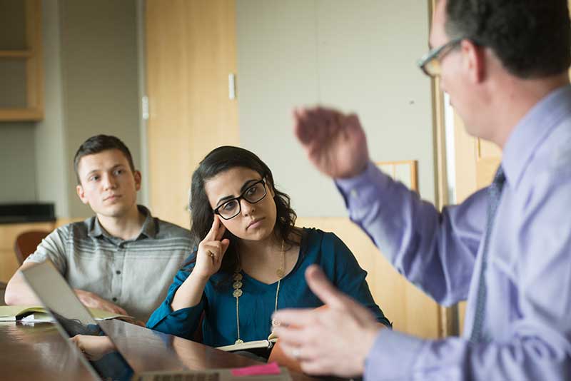 Man talking with a woman and another man in an office
