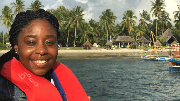 Woman wearing red life jacket with water in background