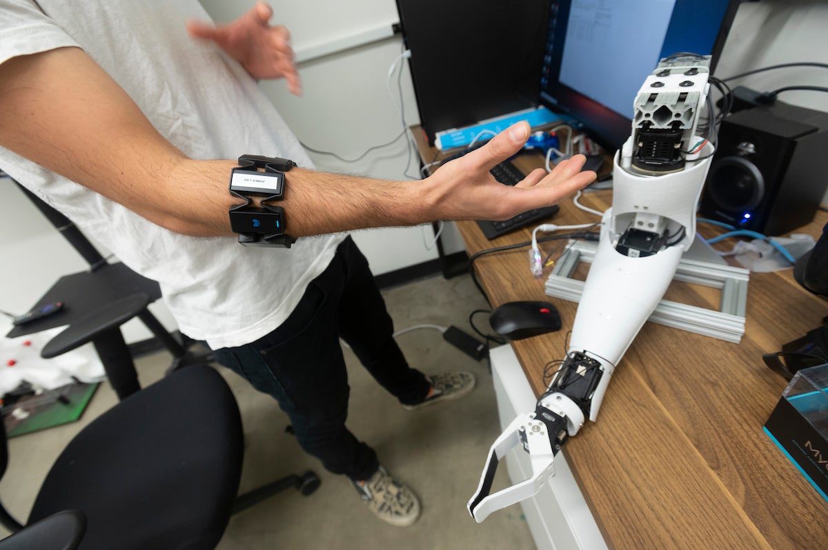 Peyton Young, a UC Davis Ph.D candidate in Jonathon Schofield’s lab, demonstrates how electromyography works using a robotic arm.  The robotic arm recognizes the electrical signals from his forearm muscles and it moves accordingly. (Greg Urquiaga/UC Davis)