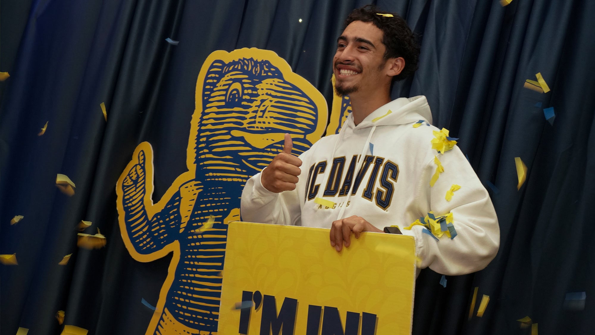 New UC Davis student Gabriel Hernandez from Modesto, California, poses with a cutout of Gunrock during Aggie Day 2023. (Karin Higgins/UC Davis)