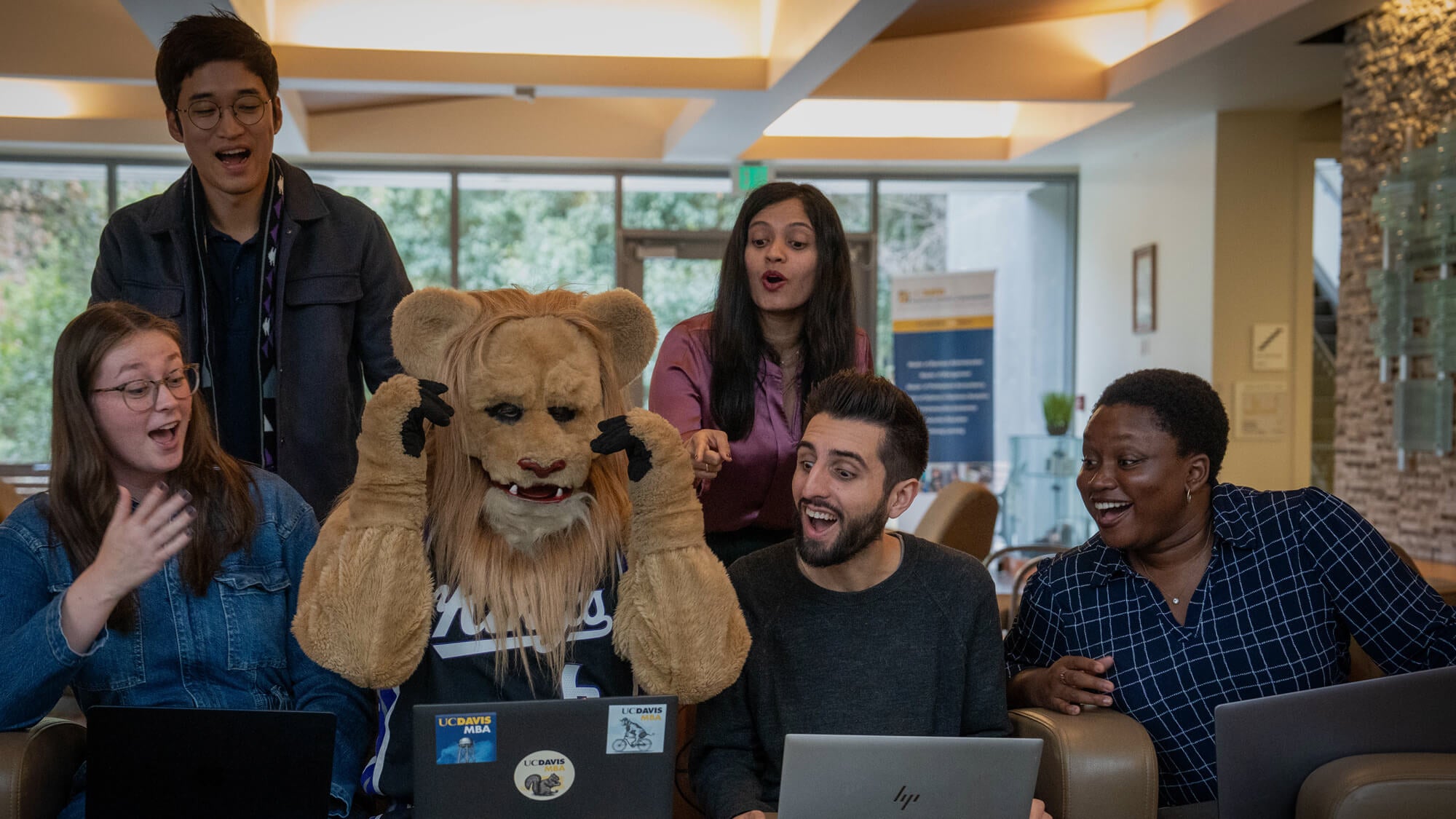 UC Davis MBA students enjoy an impromptu visit from Slamson the Lion, bringing smiles and a playful break to their study group. (Tim McConville/UC Davis)