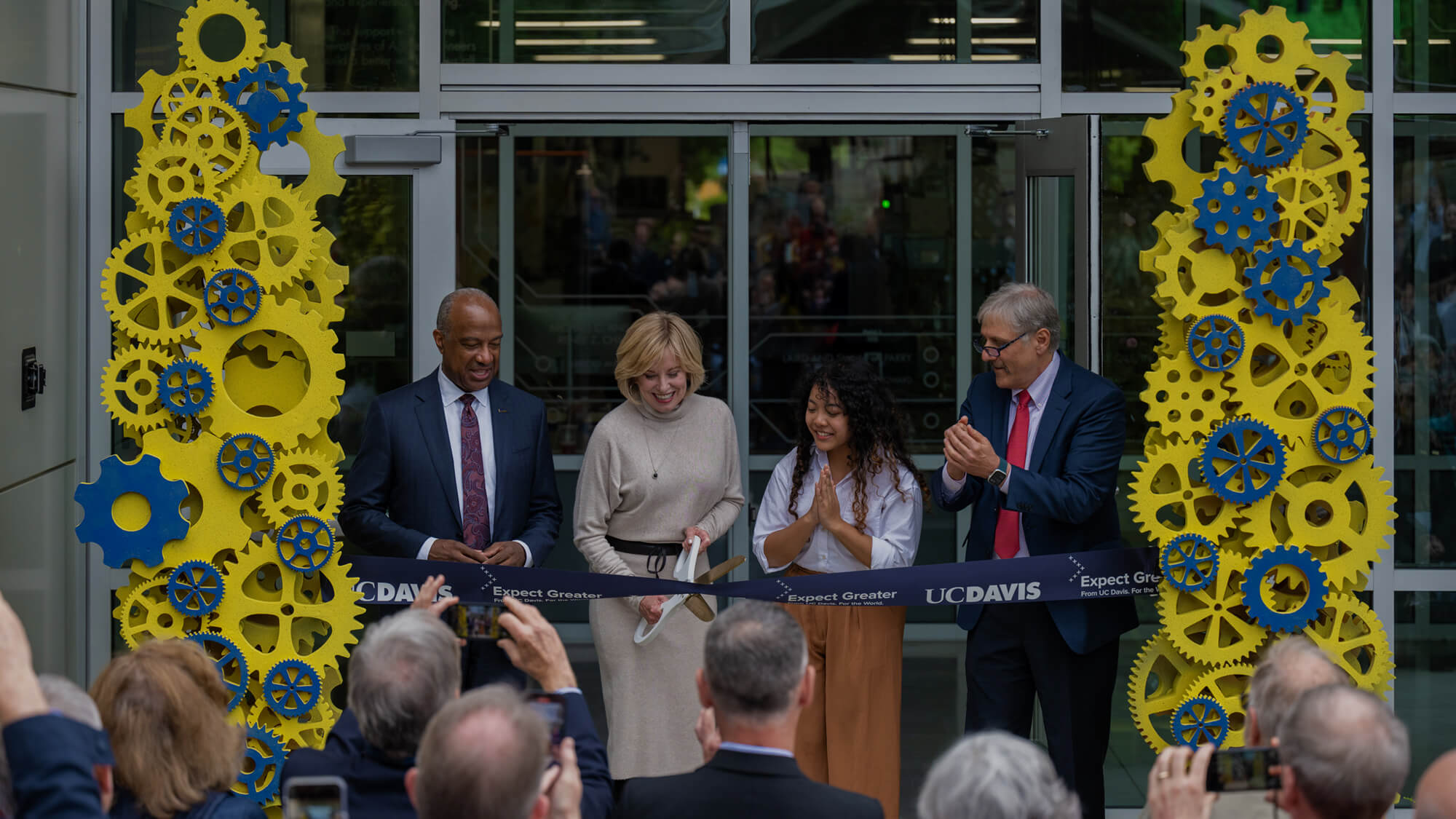 Diane Bryant ’85 cuts the ribbon to open the Engineering Student Design Center that bears her name as Chancellor Gary S. May, mechanical engineering major Tichada Tantasirikorn and Dean Richard Corsi look on. (José Luis Villegas/UC Davis)