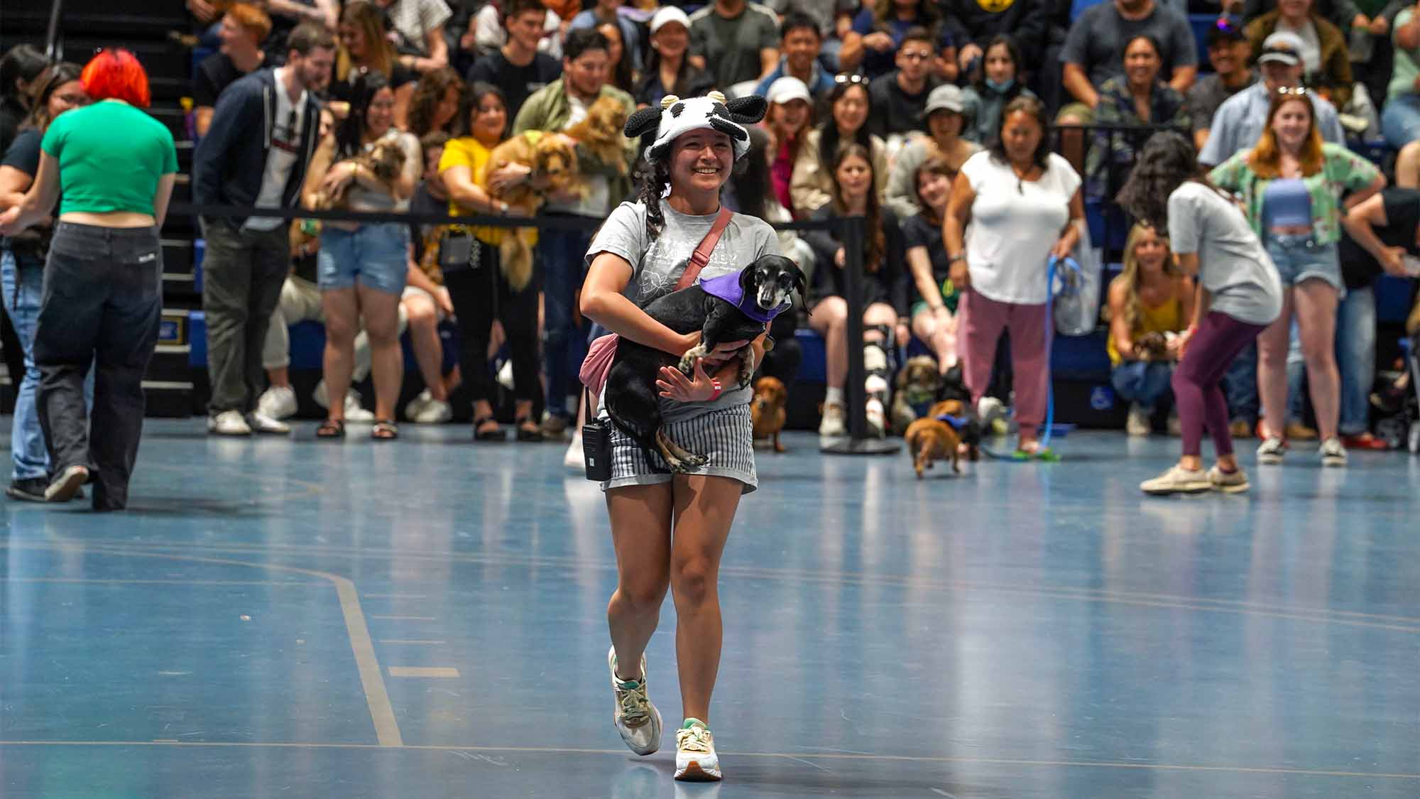 Student carries dog at Doxie Derby