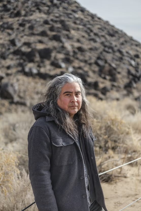 Native man in coat with natural environment in background
