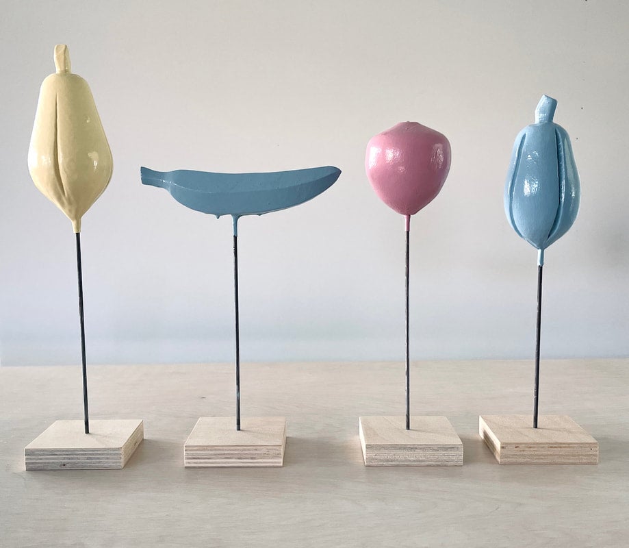 Depictions of fruit on sticks in pastel colors represented in art display