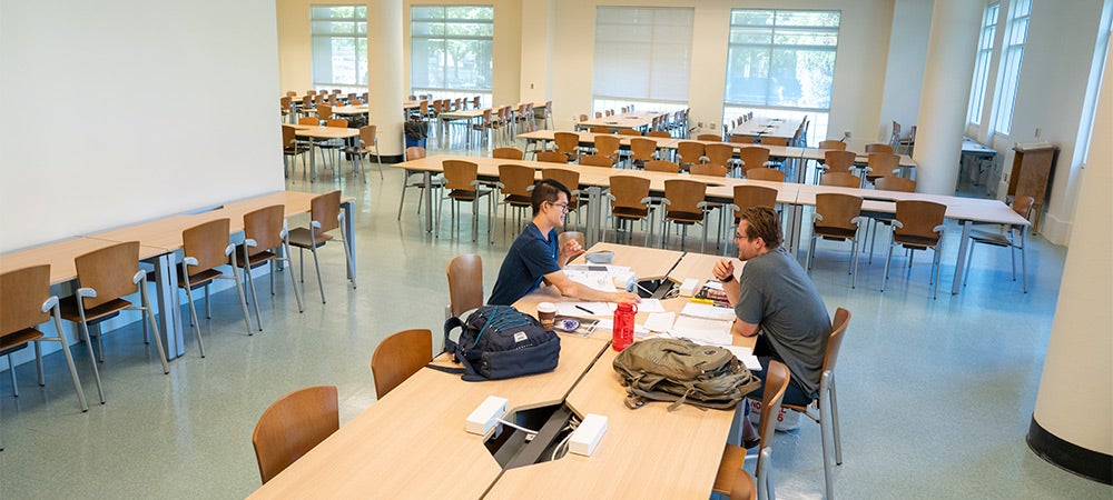 students fill the desks and tables in a brightly lit study room