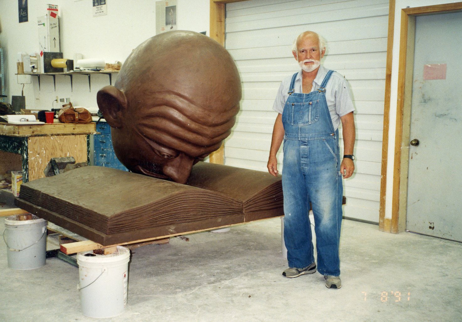 Robert Arneson Stands by the bronze Bookhead before it is installed. 