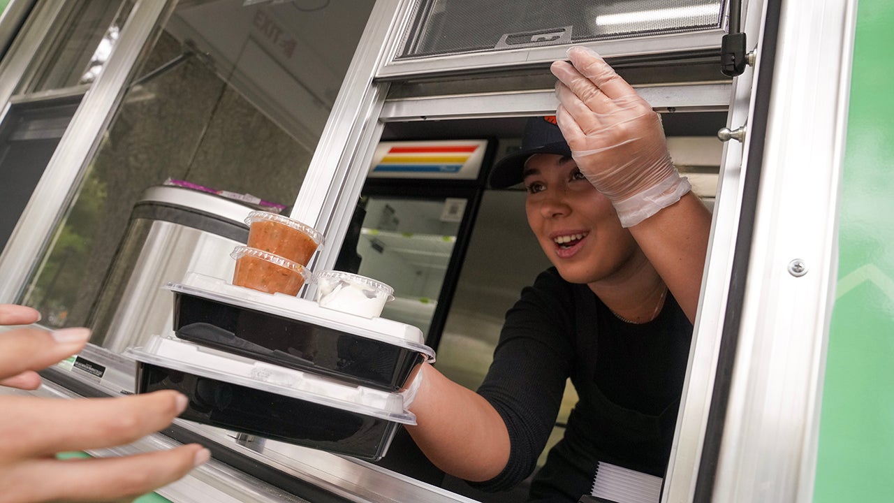 Bianca Tomat serves two meals through the window of the AggieEats food truck.