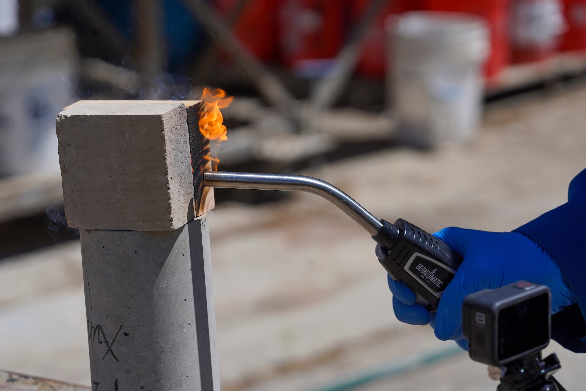 A close-up of a wood block and earth block and a blowtorch