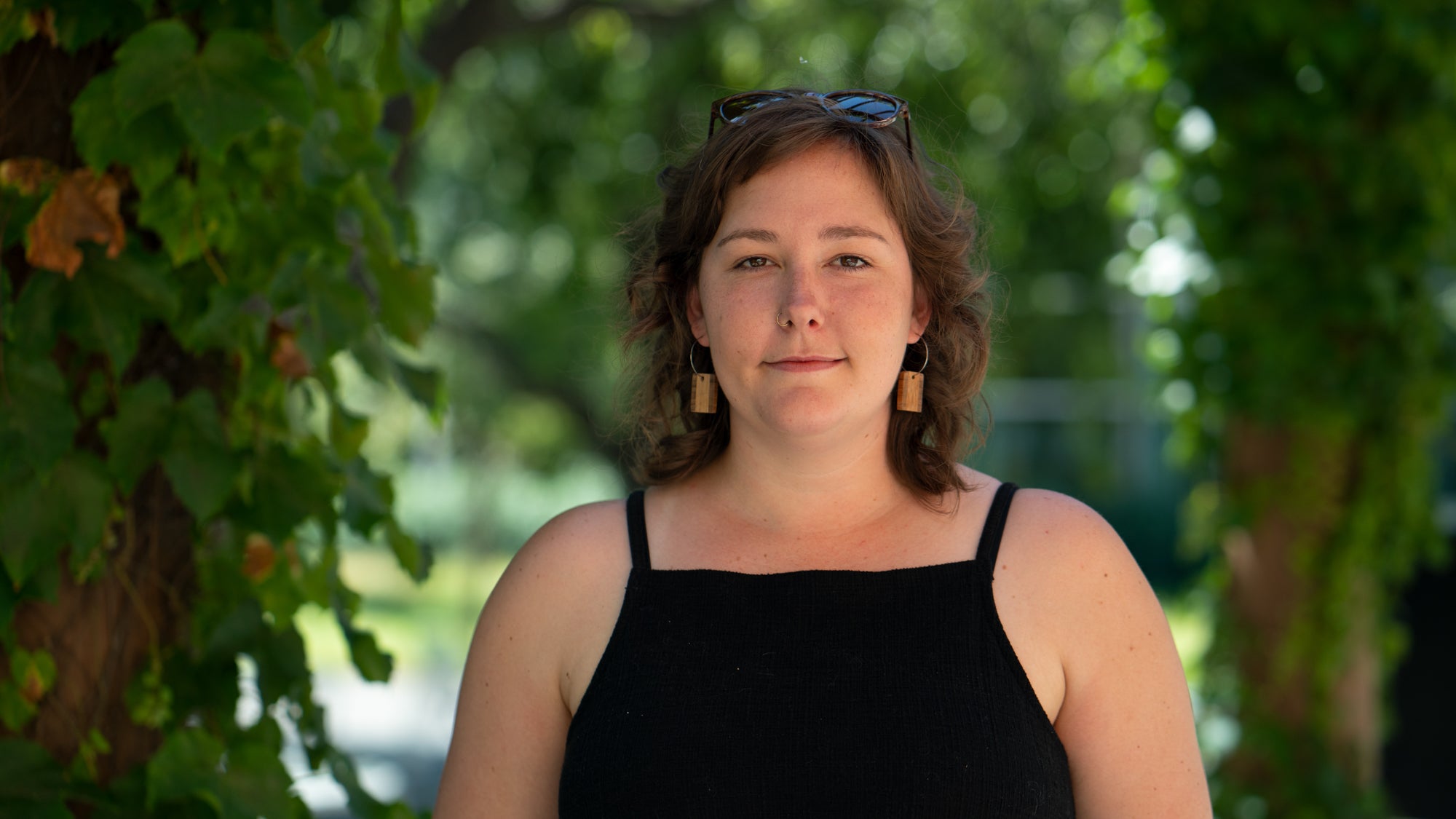 Polar ecologist Amanda Frazier in black tank top and tree leaves in background