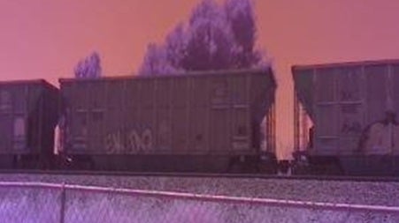 purple-tinged color highlights passing coal train shot with scientific monitoring device