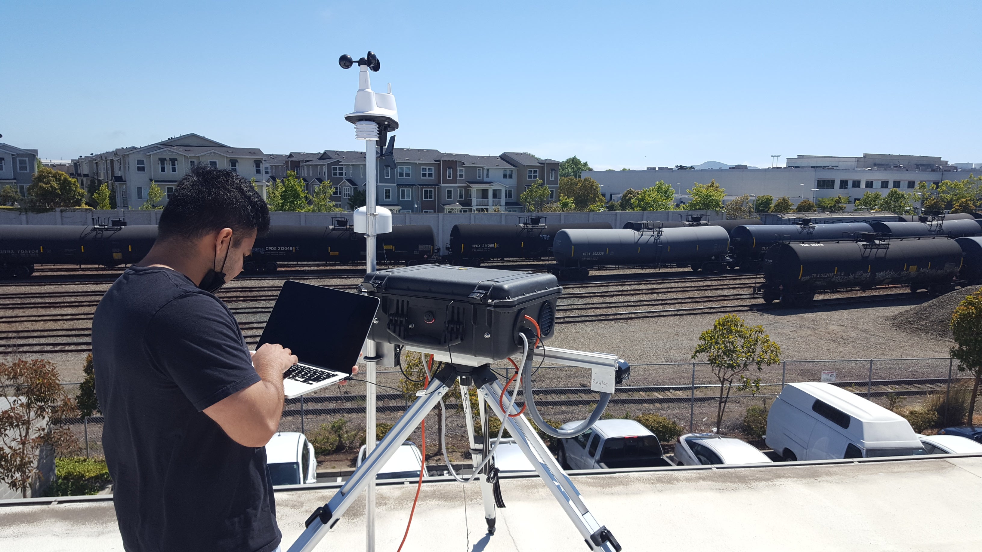 Scientist carrying clipboard checks monitoring system at Richmond train holding yard