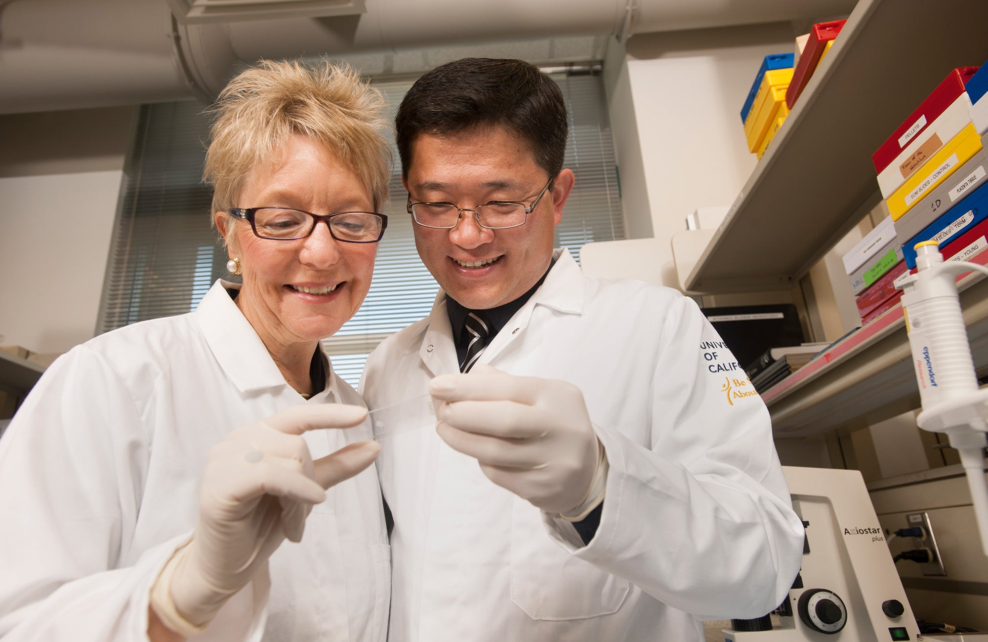 Farmer and Wang in white coats in a lab