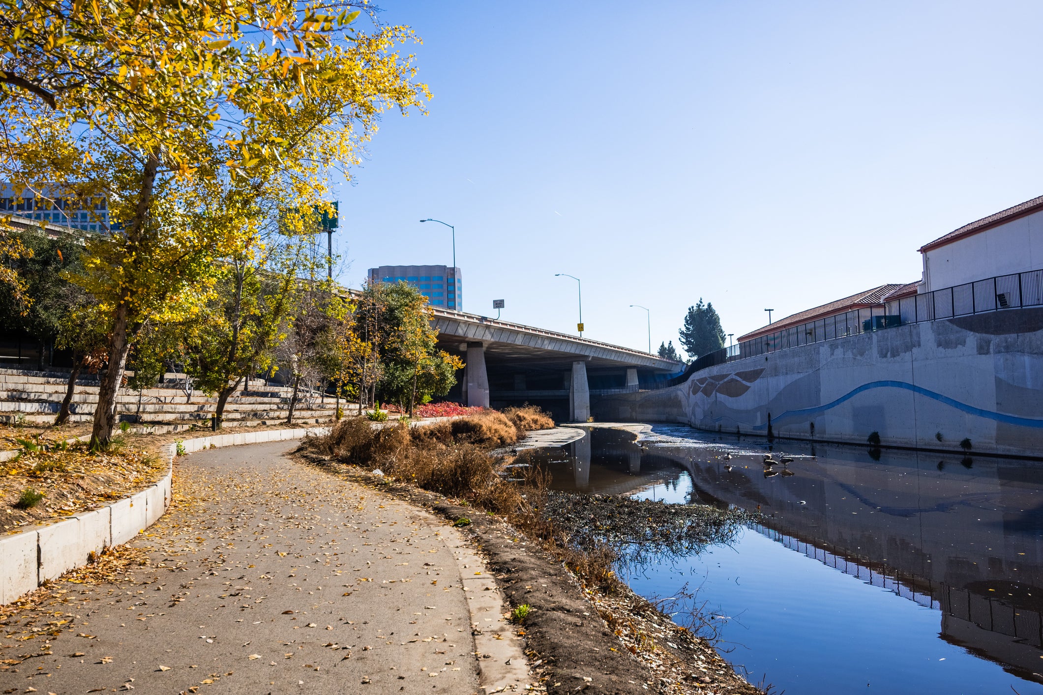The Guadalupe River in San Jose, CA runs along an urban sidewalk  