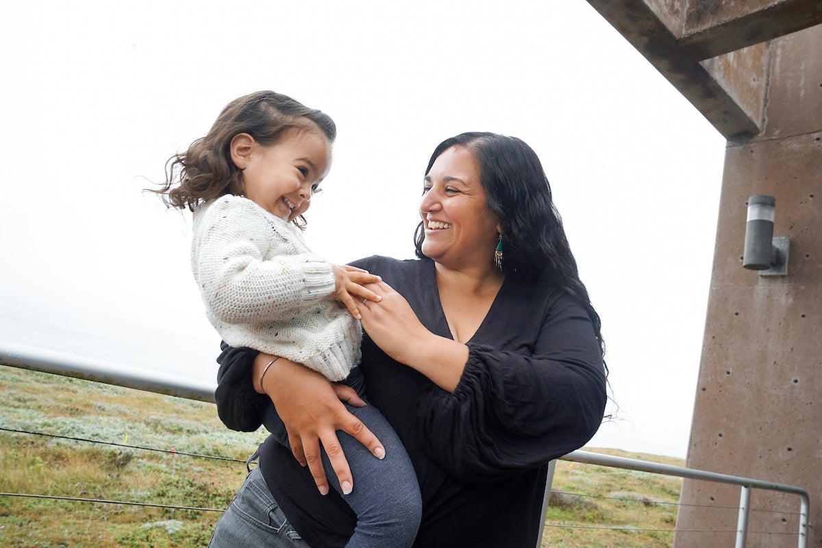 Scientist Alyssa Griffin holds her daughter with backdrop of Bodega Bay