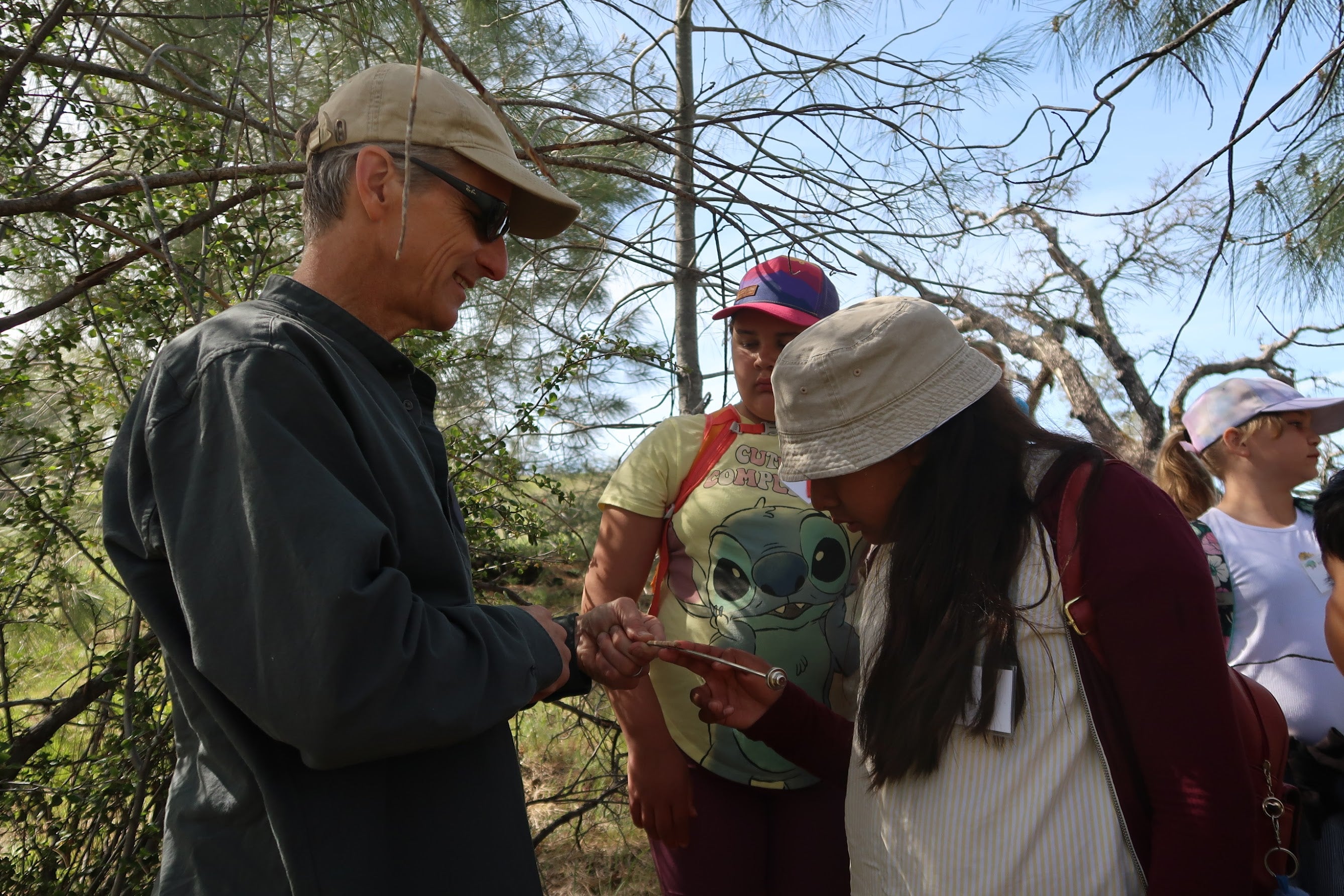 Andrew Latimer points to a recent tree core while students observe