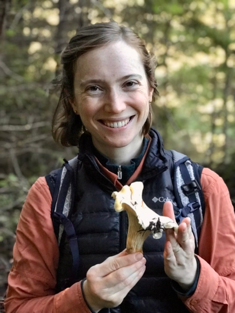 Laura Bogar smiles while holding chanterelle mushroom