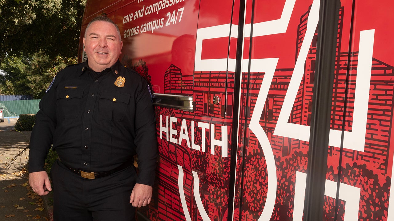 Nathan Trauernicht, chief of the UC Davis Fire Department, stands beside the Health 34 van.