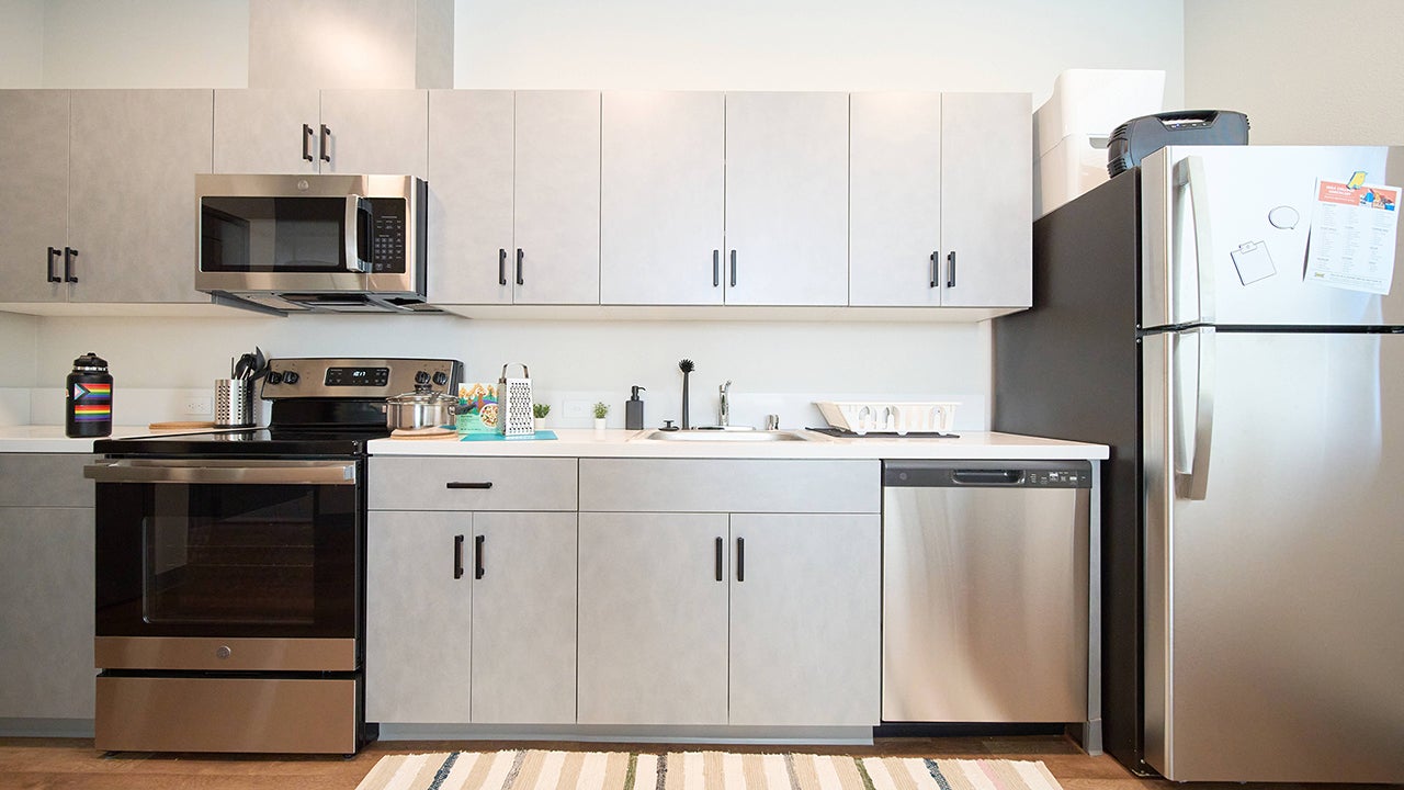 A kitchen in a graduate student apartment features stainless steel appliances