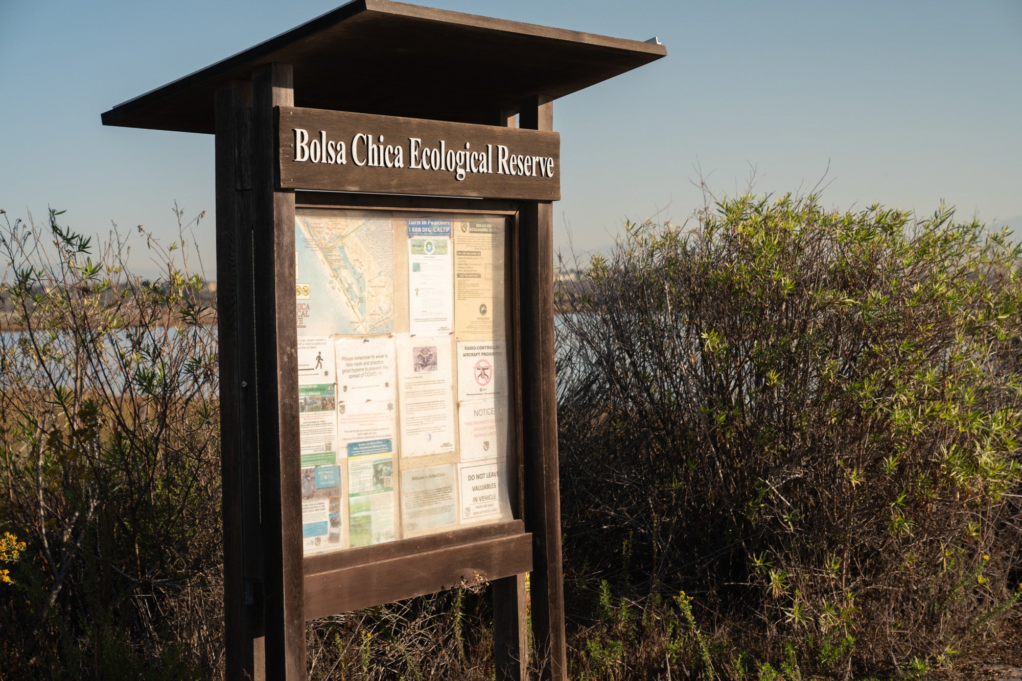 A wooden sign says Bolsa Chica Ecological Reserve