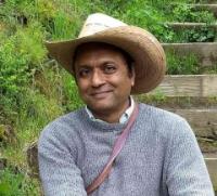 Head and shoulders of man in sweater wearing large hat