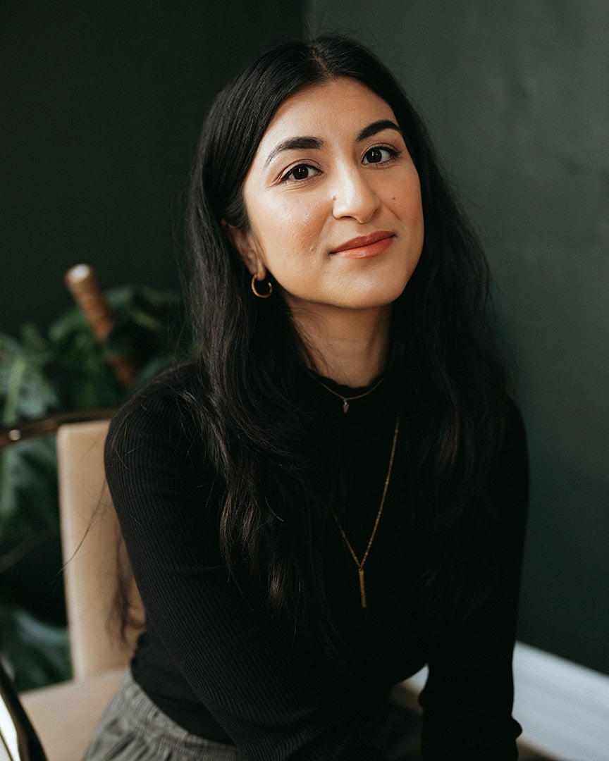 Young woman sits on a chair and looks into the camera
