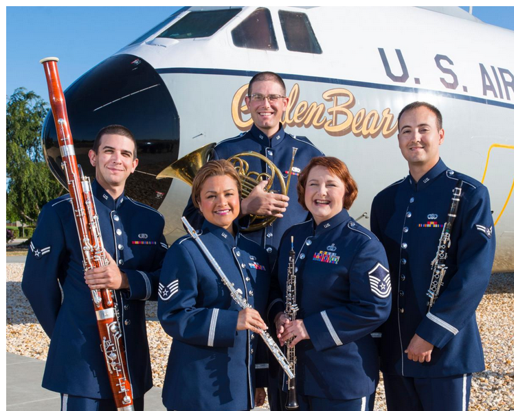 Wind instrument players standing in front of a plane.