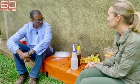 CBS anchor Bill Whittaker sits with Tierra Smiley Evans with bananas and spray bottle on bench