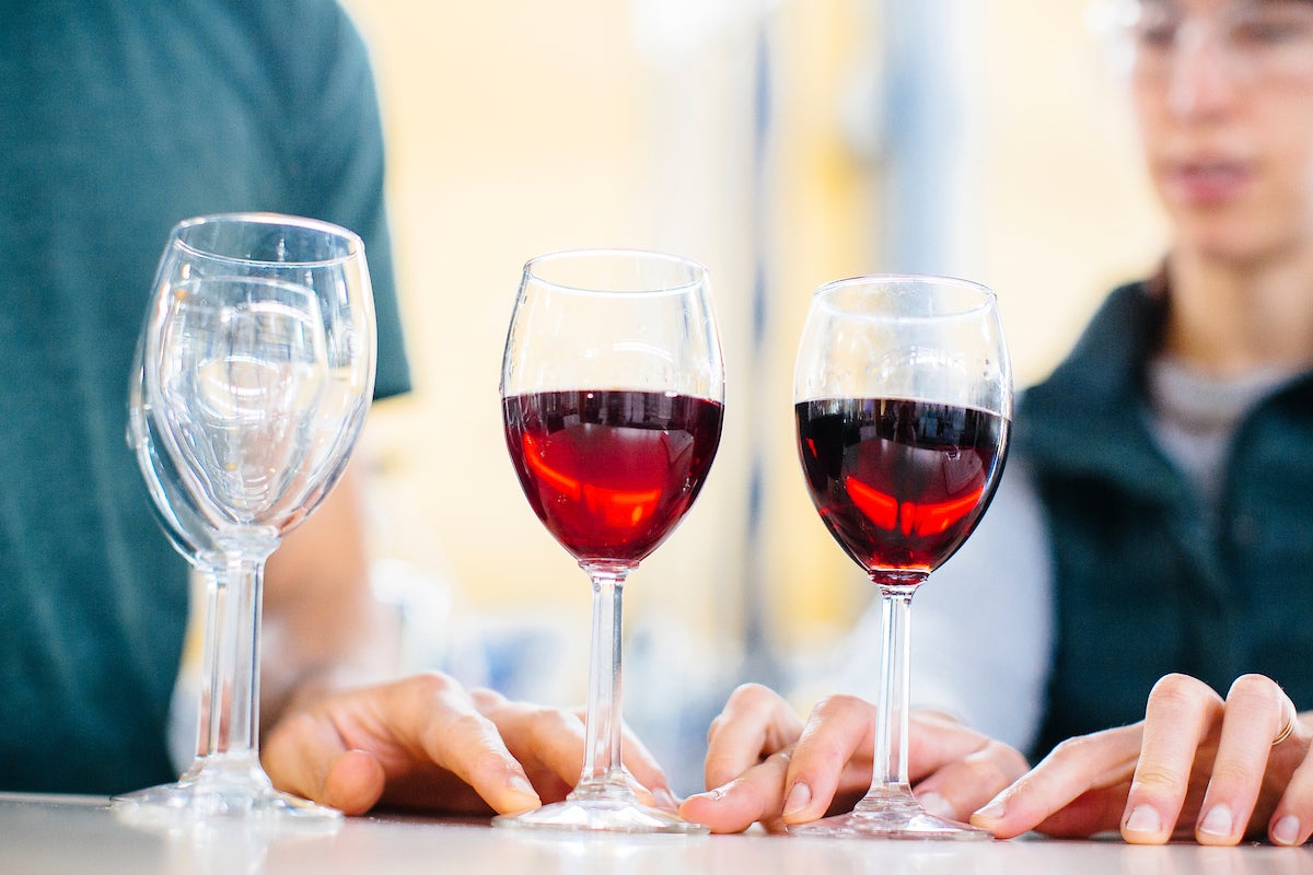 Two glasses of red wine on a table. UC Davis researchers think the flavanol quercetin, when combined with alcohol, may be the cause of "red wine headaches." (UC Davis)