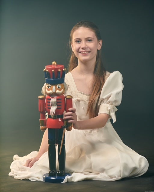 Costumed girl holds a red and blue nutcracker