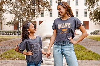 Child and adult pose in UC Davis clothing