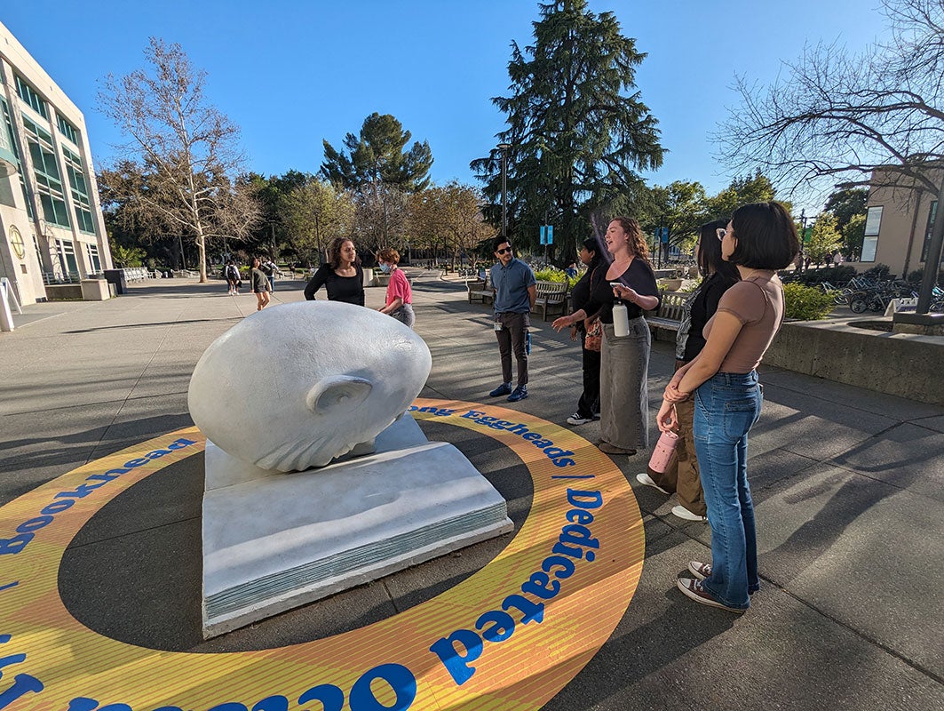 people standing in front of an egghead outside of the library