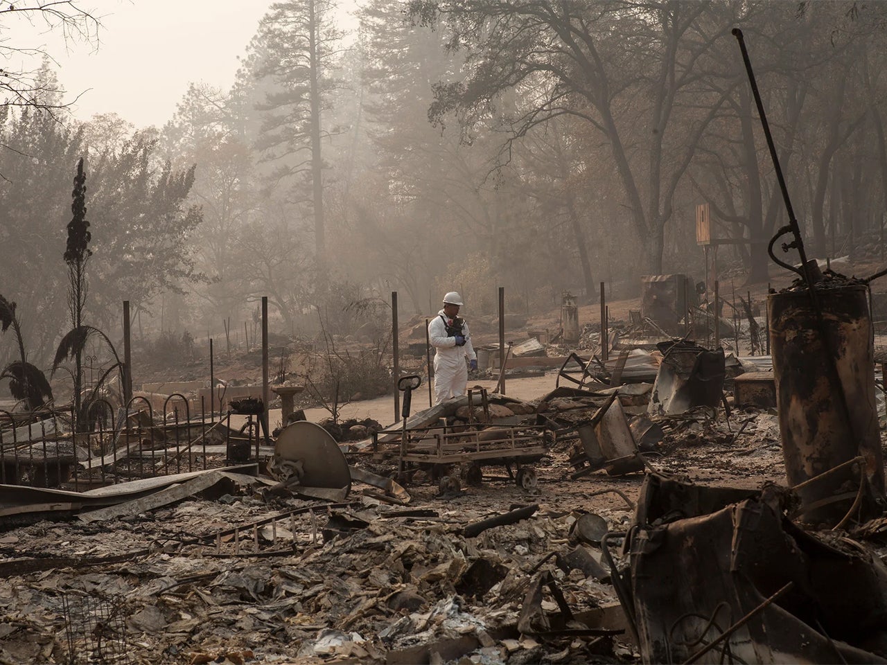 National Guard soldier in a white suit searches burned debris after 2018’s Camp Fire in Paradise, California