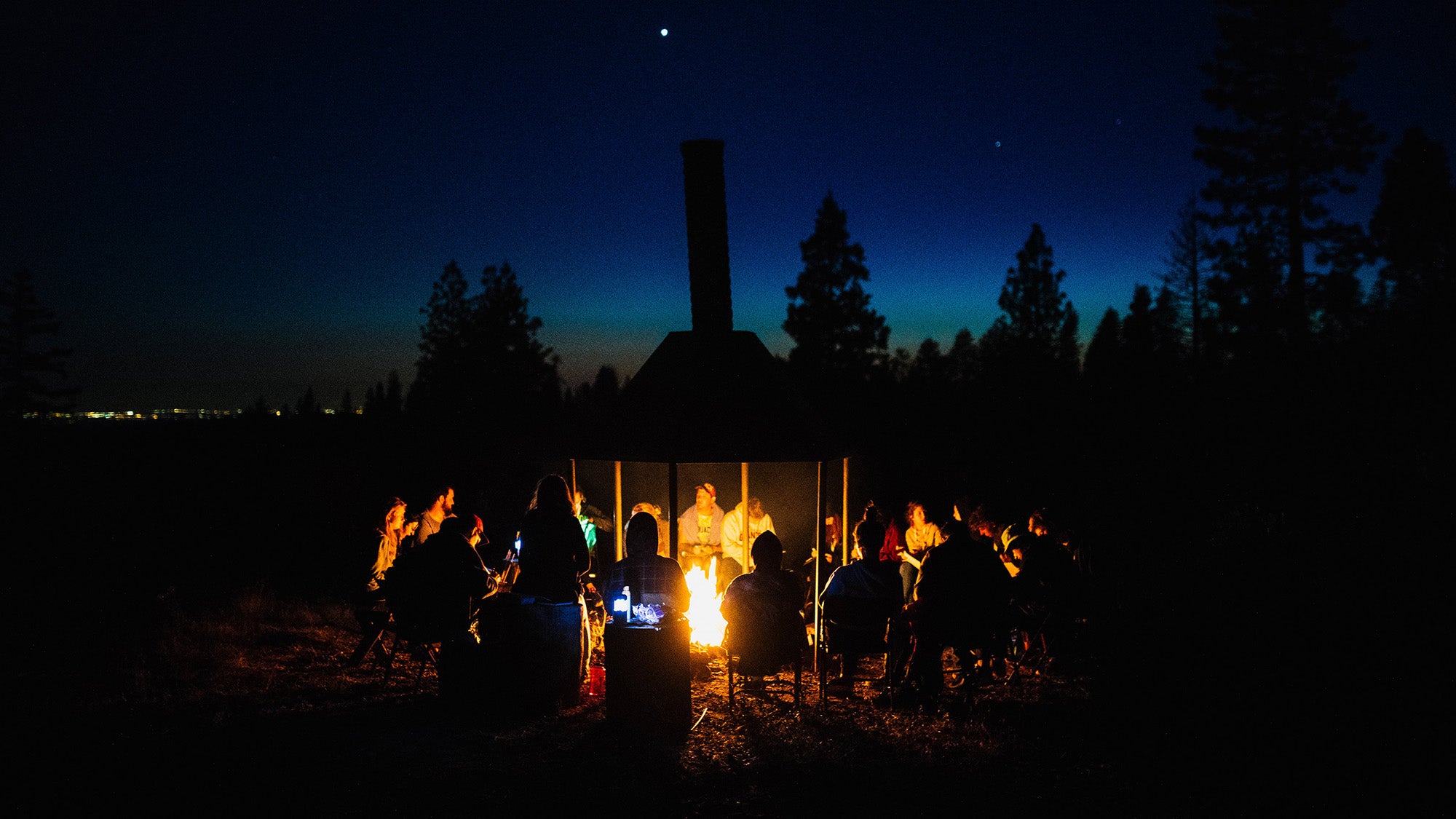 People sit around a campfire.