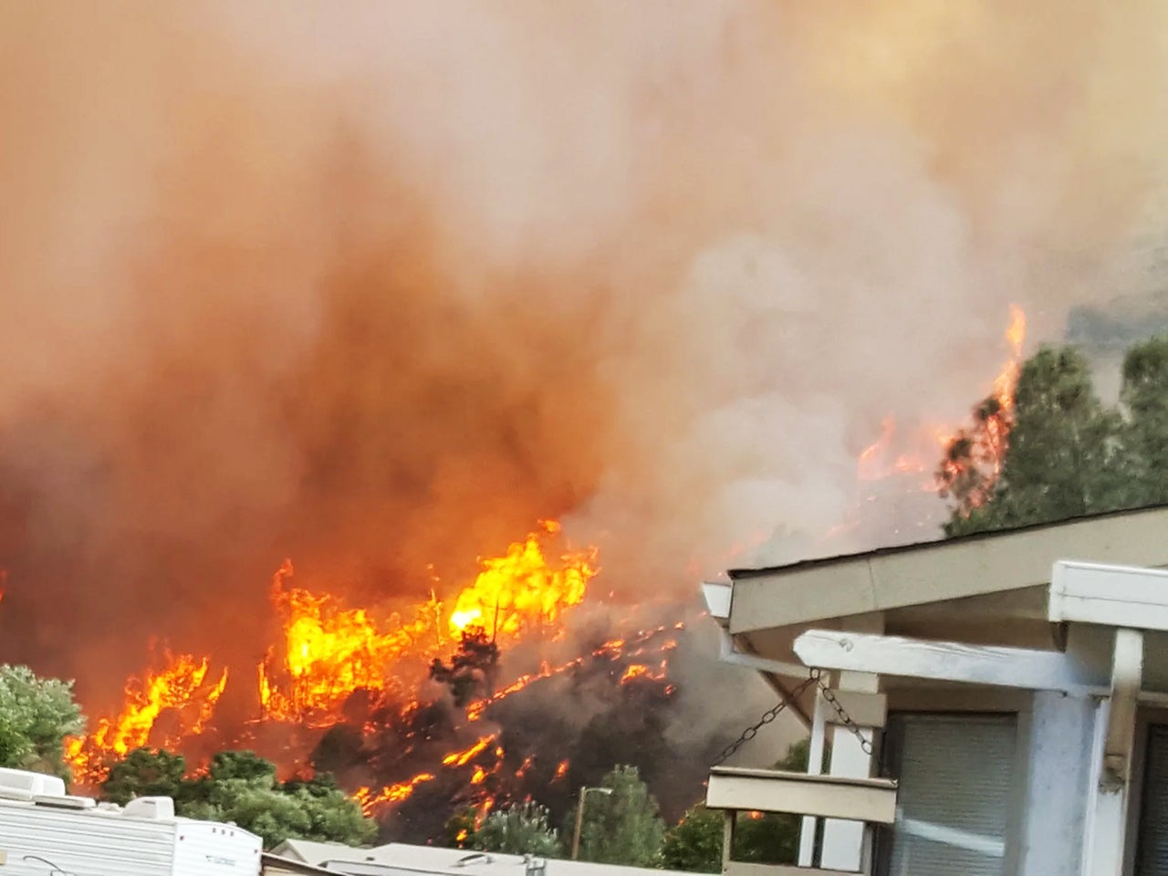 Flames and smoke rise over houses during the 2018 Carr Fire