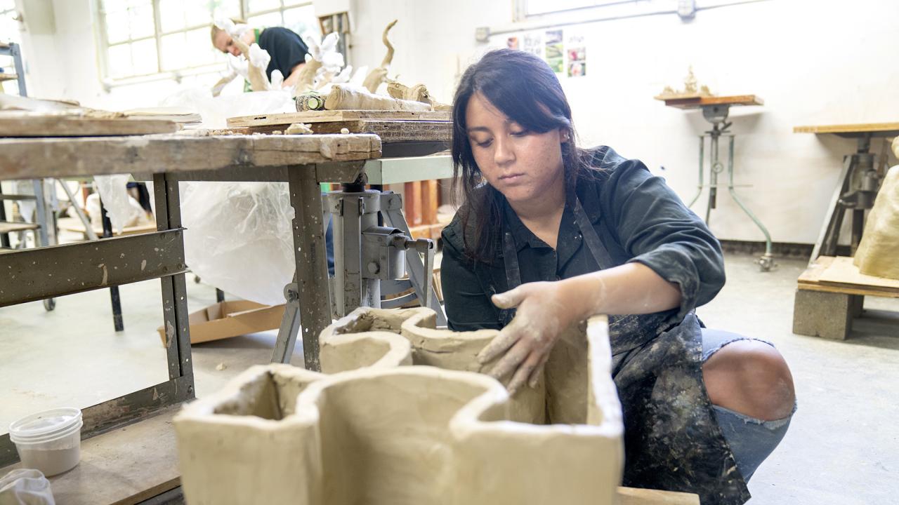 student Jacqueline Arroyo sculpting art