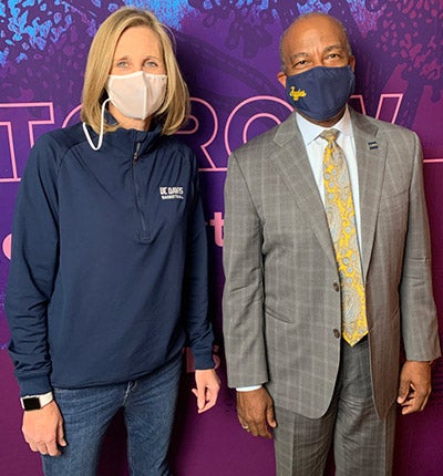 Coach Jennifer Gross poses for photo with Chancellor Gary S. May, both wearing face coverings.