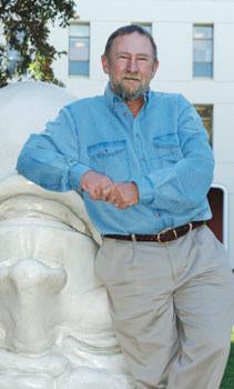 Charles J. Soderquist, portrait, leaning against Egghead sculpture in back of Mrak Hall
