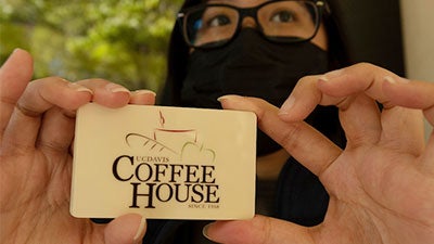 Closeup of hands holding a Coffee House gift card